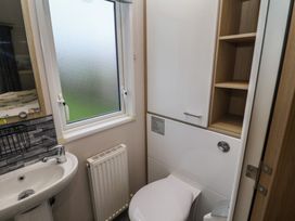 A bathroom with a toilet and sink at Offspray Court 1 Scratby