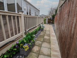 A garden path with planters and a fence at Offspray Court 1 Scratby