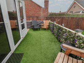 A garden with chairs and flowers at Offspray Court 1 Scratby