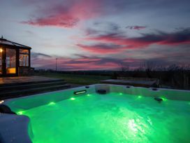 A hot tub near a building at Kestrel Cottage Llangaffo