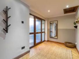 An entryway with a mirror and window at Kestrel Cottage Llangaffo