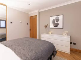 A bedroom with a bed and dresser at Kestrel Cottage Llangaffo