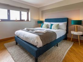 A bedroom with a bed and two lamps at Kestrel Cottage in Llangaffo