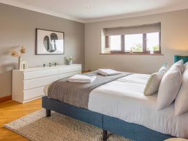 A bedroom with a bed and dresser at Kestrel Cottage in Llangaffo
