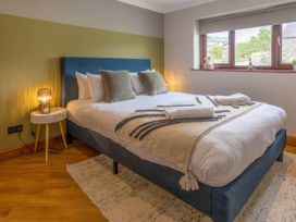 A bedroom with a bed and bedside table at Kestrel Cottage Llangaffo
