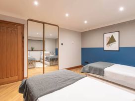 A bedroom with two beds and a mirror at Kestrel Cottage in Llangaffo