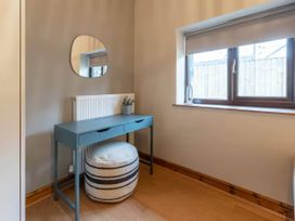 An office with a desk and a mirror at Swan Cottage in Llangaffo