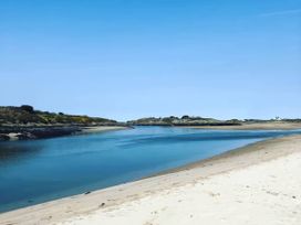 A river flowing through sand and rocks at Swan Cottage in Llangaffo