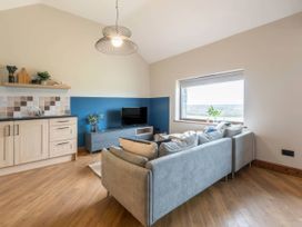 A living room with a sofa and television at Wren Cottage in Llangaffo