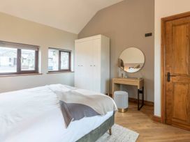 A bedroom with a bed, wardrobe, and mirror at Wren Cottage in Llangaffo