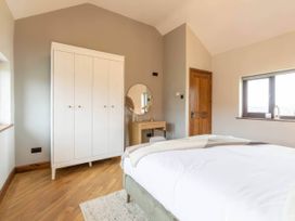 A bedroom with a bed and wardrobe at Wren Cottage in Llangaffo