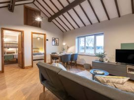 A living room with a sofa and dining table at Blue Bird Cottage in Llangaffo