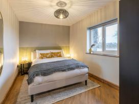 A bedroom with a bed and nightstand at Blue Bird Cottage in Llangaffo