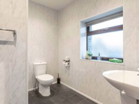 A bathroom with a toilet and sink at Blue Bird Cottage in Llangaffo