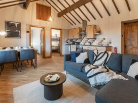 A living room with a sofa and dining table at Blue Bird Cottage in Llangaffo