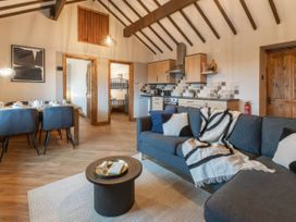 A living room with a kitchen and dining area at Blue Bird Cottage in Llangaffo