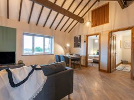 A living room with a sofa and dining table at Blue Bird Cottage in Llangaffo