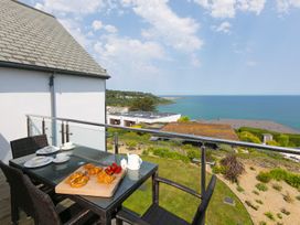 A balcony with a table and chairs overlooking the sea at Mid Air St. Ives
