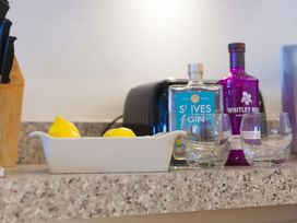 A kitchen countertop with gin bottles, glasses, and lemons at Mid Air in St. Ives