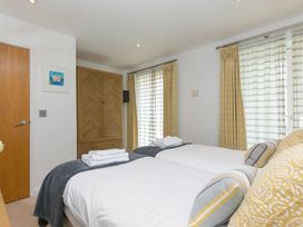 A bedroom with two beds and a wardrobe at Mid Air in St. Ives