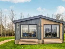 A cabin with large windows and steps at Isca Lodge in Wombleton