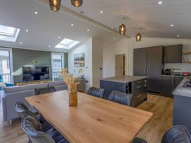 A dining room with a table and chairs at Isca Lodge in Wombleton