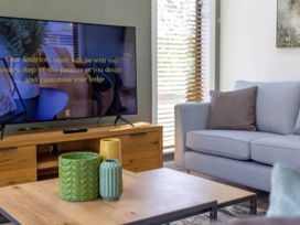 A living room with a television and decorative vases at Isca Lodge Wombleton
