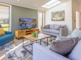 A living room with a television and coffee table at Isca Lodge in Wombleton