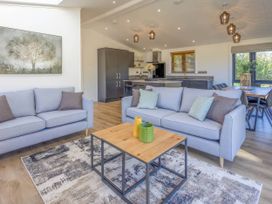 A living room with a sofa and table at Isca Lodge in Wombleton