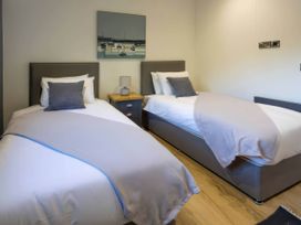 A bedroom with two beds and a nightstand at Isca Lodge in Wombleton