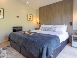 A bedroom with a bed and nightstand at Rye Lodge in Wombleton