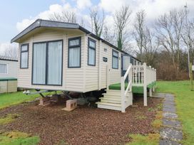 A mobile home with a deck and stairs at Caravan number 77