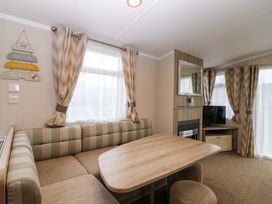 A living room with a sofa and table in Caravan number 77