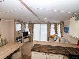 A living room with a sofa and TV at Caravan number 77