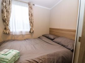 A bedroom with a bed and window at Caravan number 77