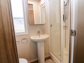 A bathroom with a sink, shower, and toilet at Caravan number 77
