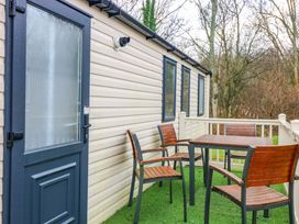 An outdoor patio with a table and chairs at Caravan number 77
