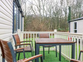 A table and chairs on a deck at Caravan number 77