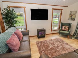 A living room with a television and sofa at Oak Lodge Admaston near Abbots Bromley