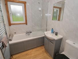 A bathroom with a bathtub and a sink at Oak Lodge in Admaston near Abbots Bromley