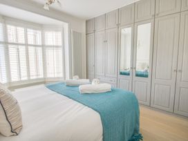 A bedroom with a bed and wardrobe at Seahorse Cottage in Weymouth