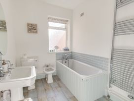 A bathroom with a bathtub, sink, toilet, and bidet at Seahorse Cottage, Weymouth