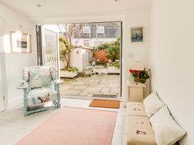 A living room with a chair and garden view at Seahorse Cottage in Weymouth