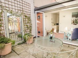 An outdoor patio with a table and chairs at Seahorse Cottage in Weymouth