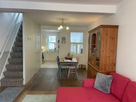 A living room with staircase and dining area at Seahorse Cottage in Weymouth