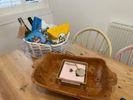 A dining room table with a basket of snacks and drinks at Seahorse Cottage in Weymouth