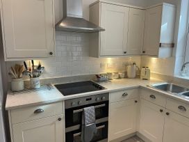 A kitchen with cabinets and appliances at Seahorse Cottage in Weymouth