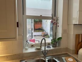 A kitchen with a sink and window showing a garden at Seahorse Cottage in Weymouth