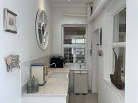 A kitchen with a sink and refrigerator at Seahorse Cottage in Weymouth