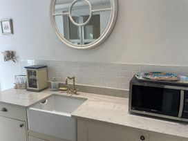 A kitchen with a sink, microwave, and countertop at Seahorse Cottage in Weymouth